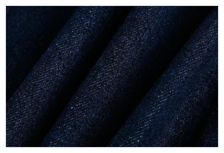 Close-up of dark navy fabric with a fine woven texture and diagonal folds.