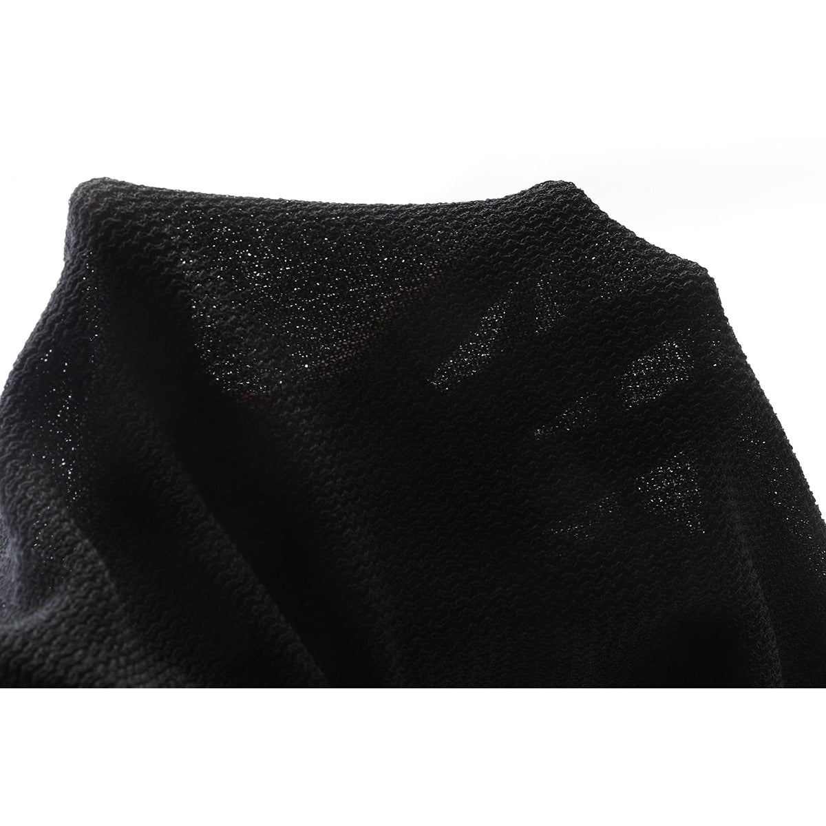 Close-up showing the open, textured knit of black fabric.