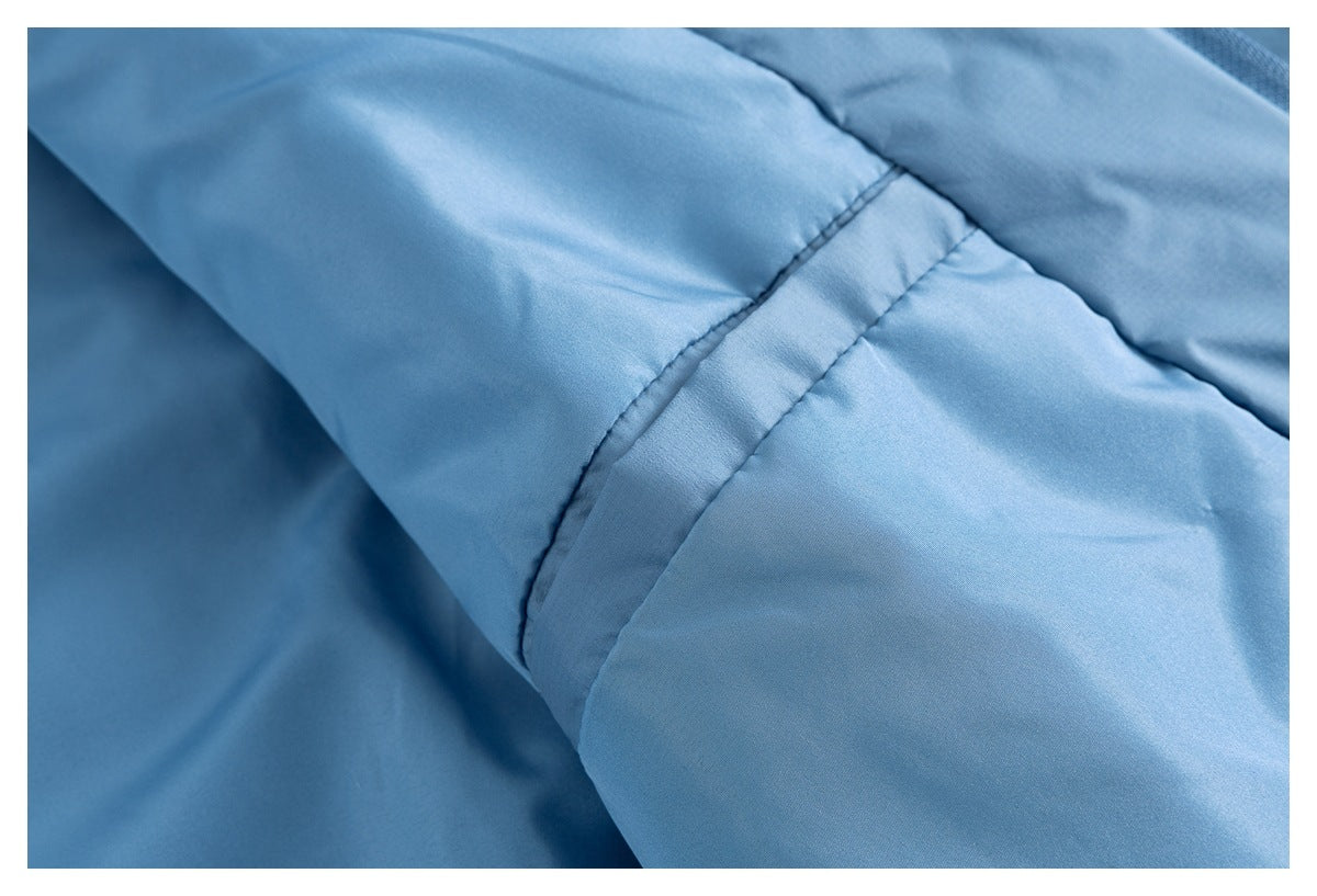 Close-up of the blue jacket's sleeve seam and smooth padded panels.