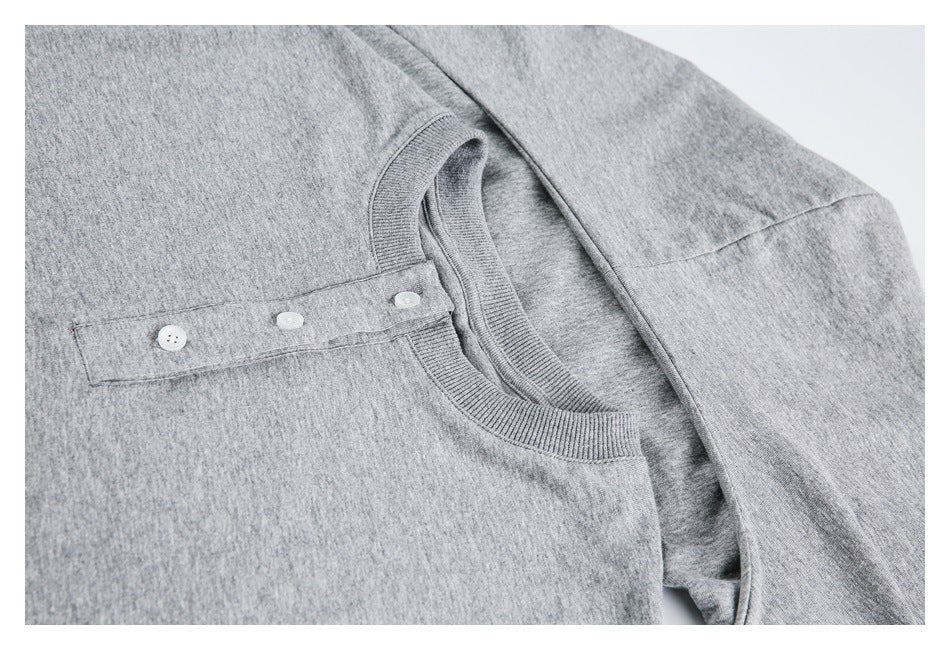 Angled close-up of the gray top's ribbed neckline and three-button placket.