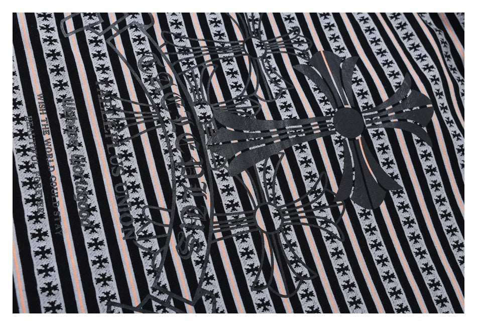Close-up of striped garment fabric with large black ornamental graphics and lettering printed on it.