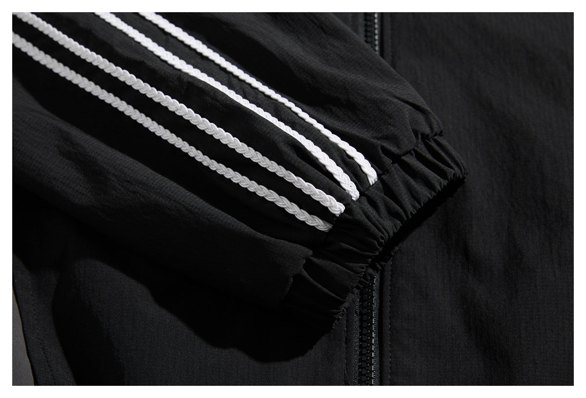 Close-up of white braided stripes along the sleeve of a black jacket near its gathered cuff.