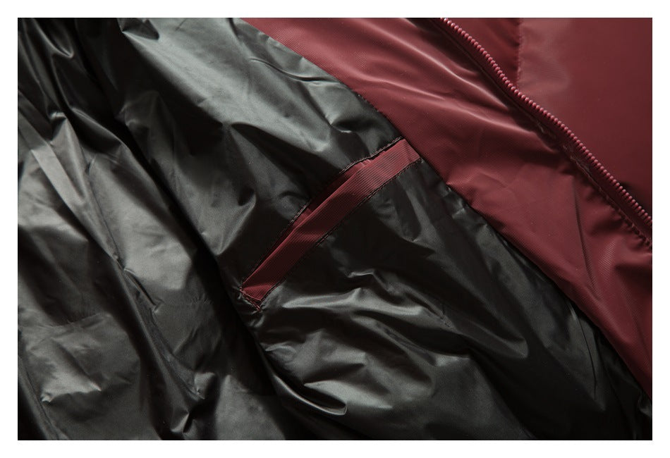 Close-up of a burgundy-trimmed pocket inside the jacket against its black lining.