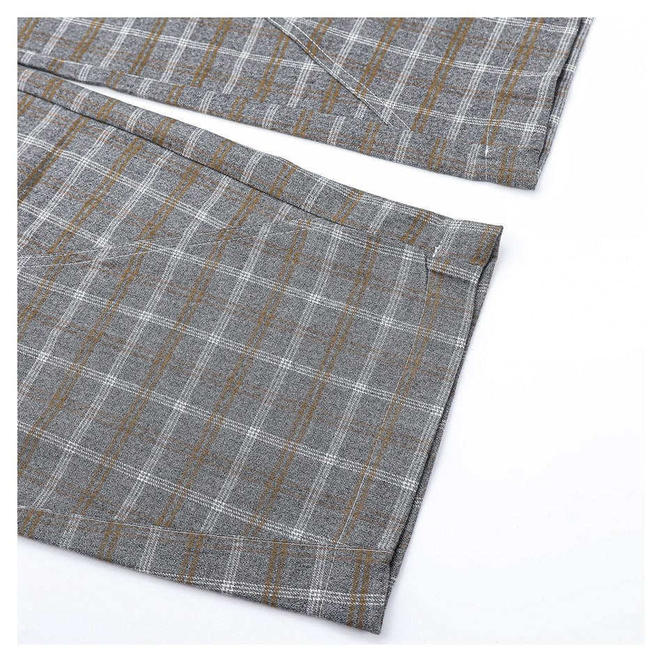 Close-up of the gray plaid trouser legs and stitched hems.