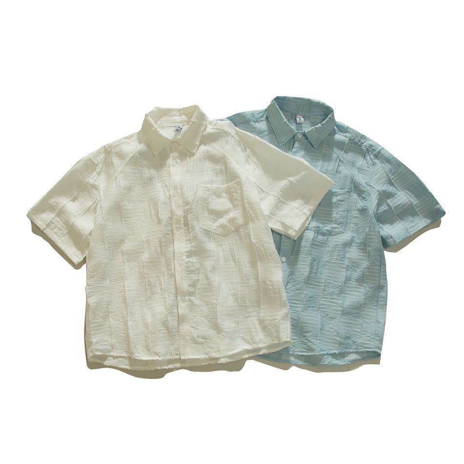 Two flat-lay short-sleeved button-up shirts with textured panels: one ivory and one pale blue.