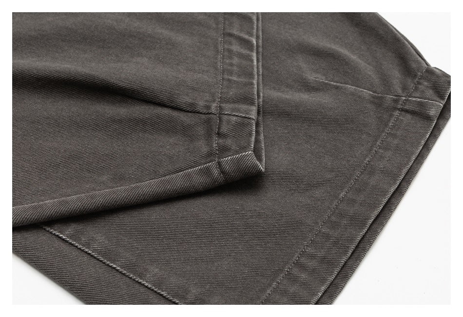Close-up of dark charcoal pants showing folded hems and neat seam stitching.