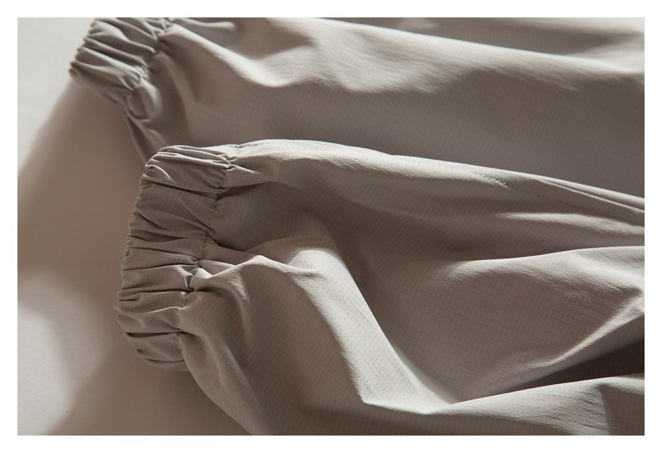 Close-up of a taupe garment's gathered, elasticized edge and softly folded fabric.