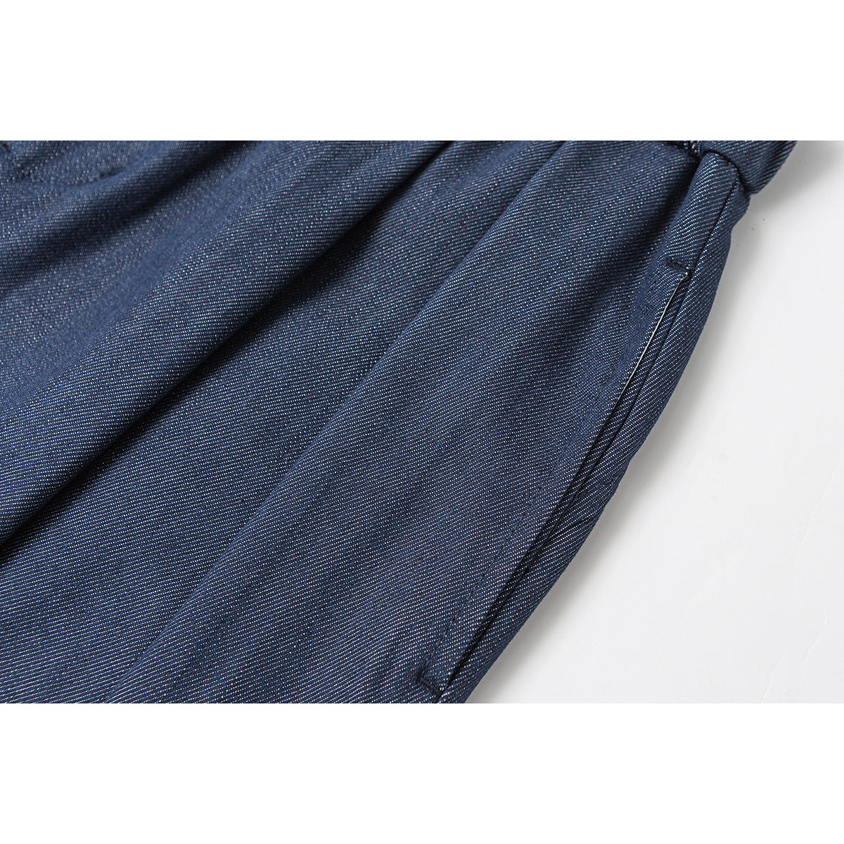 Close-up of navy fabric and a stitched side pocket on wide-leg shorts.