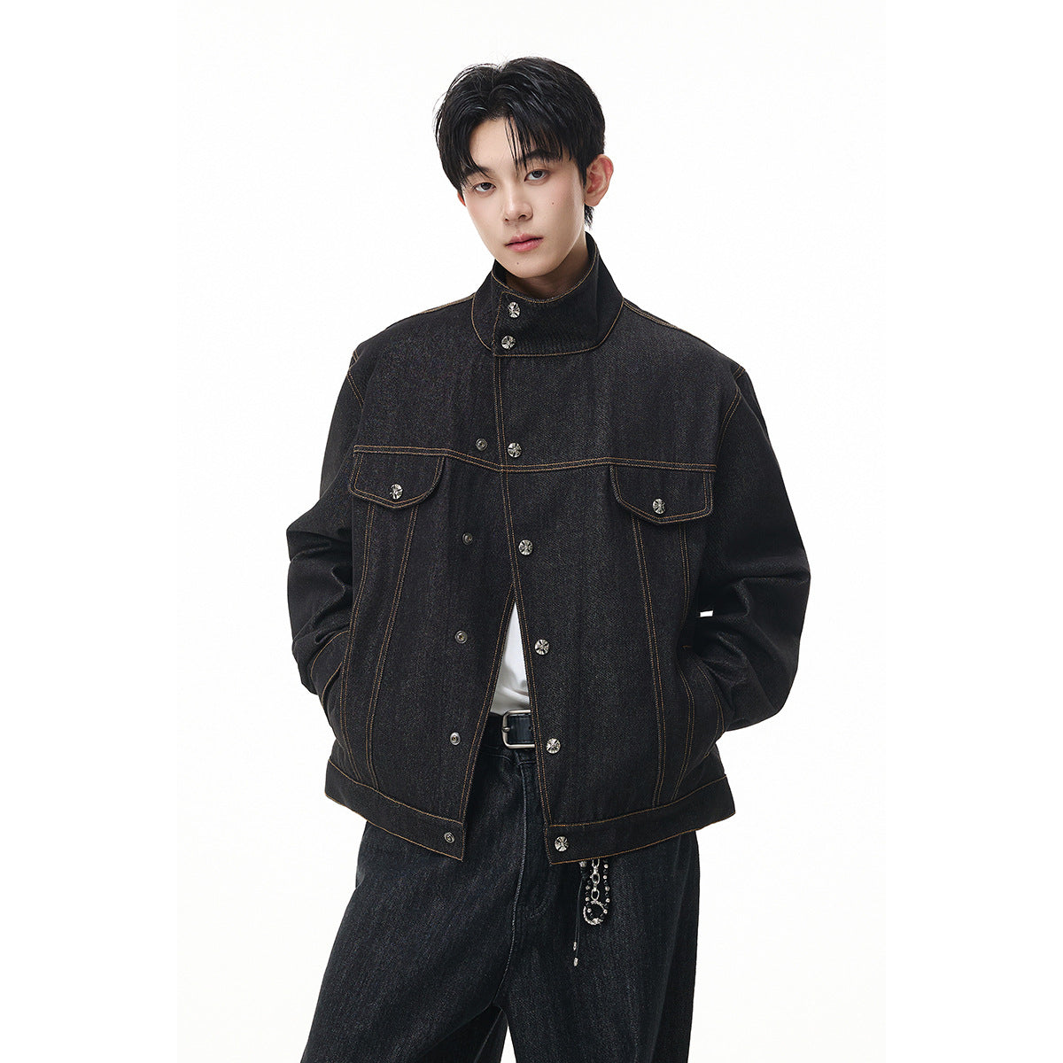 Model wearing a dark denim jacket with a high buttoned collar, contrast stitching and flap pockets.