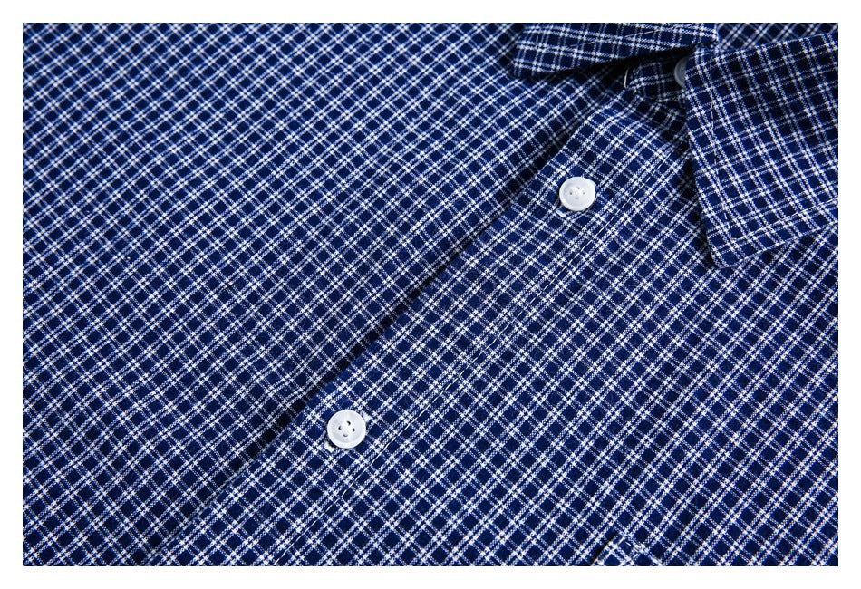 Close-up of white buttons and the placket on a navy-and-white checked shirt.
