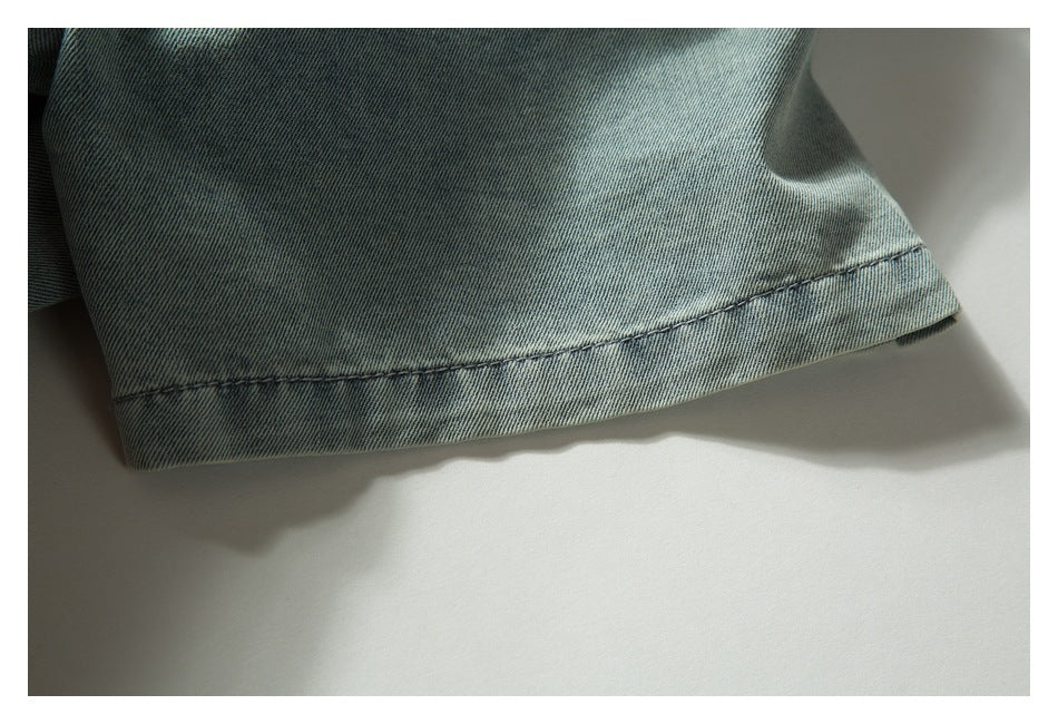 Close-up of a light blue denim sleeve cuff with visible stitching.