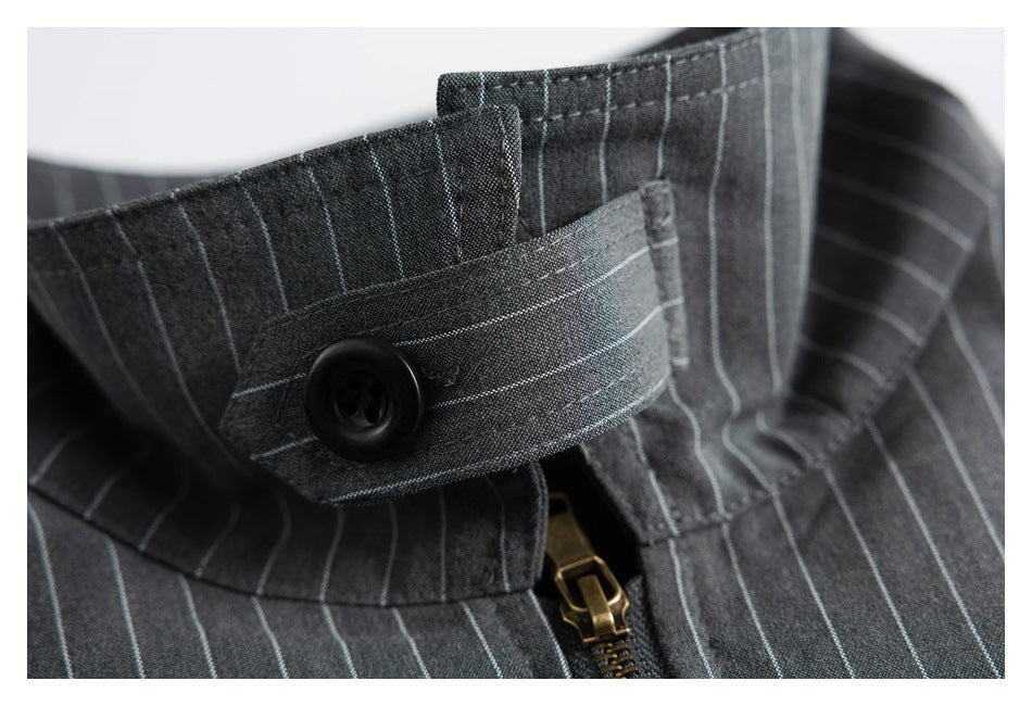 Close-up of a charcoal pinstripe collar tab with a black button and brass-colored zipper.