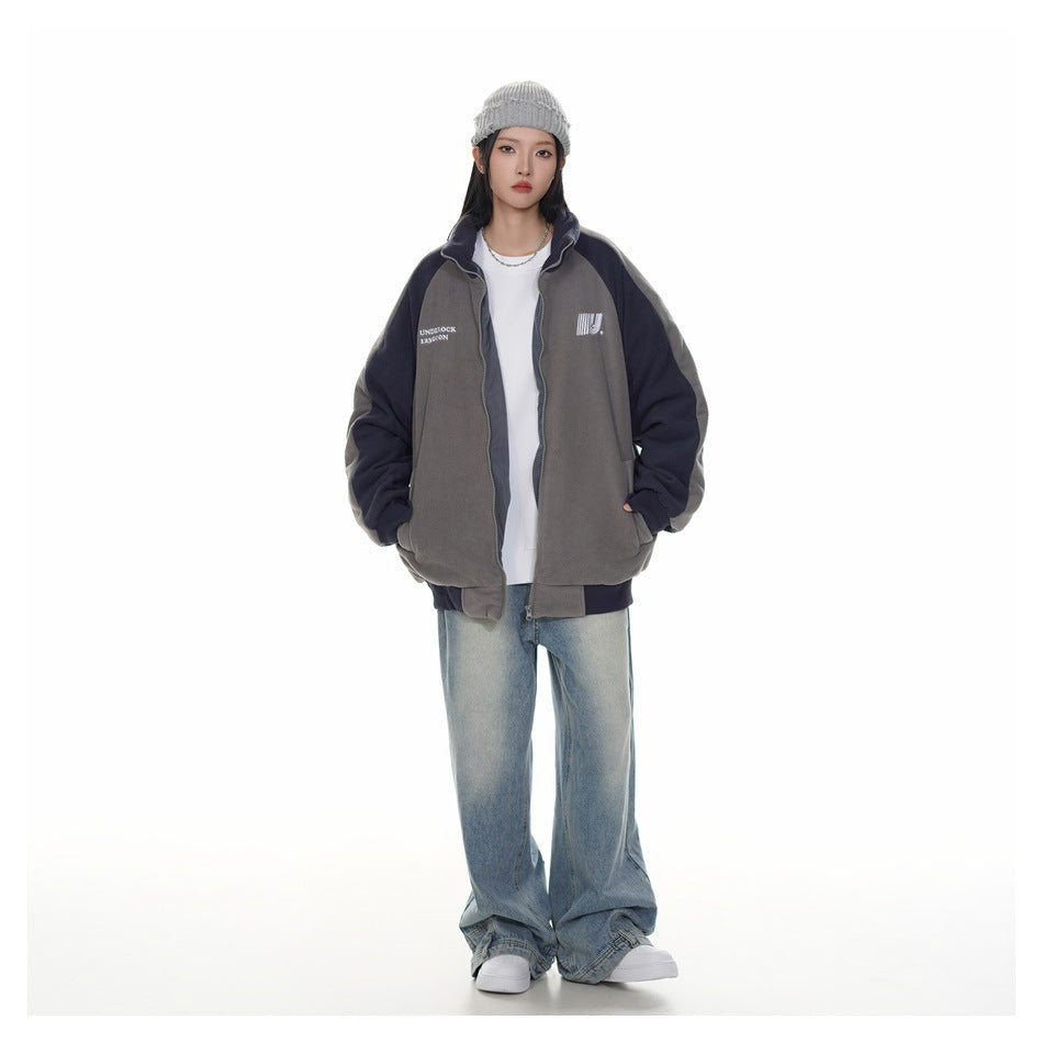 Full-length model wearing an open charcoal gray and navy zip-up jacket, white shirt, loose jeans, and a gray knit beanie.