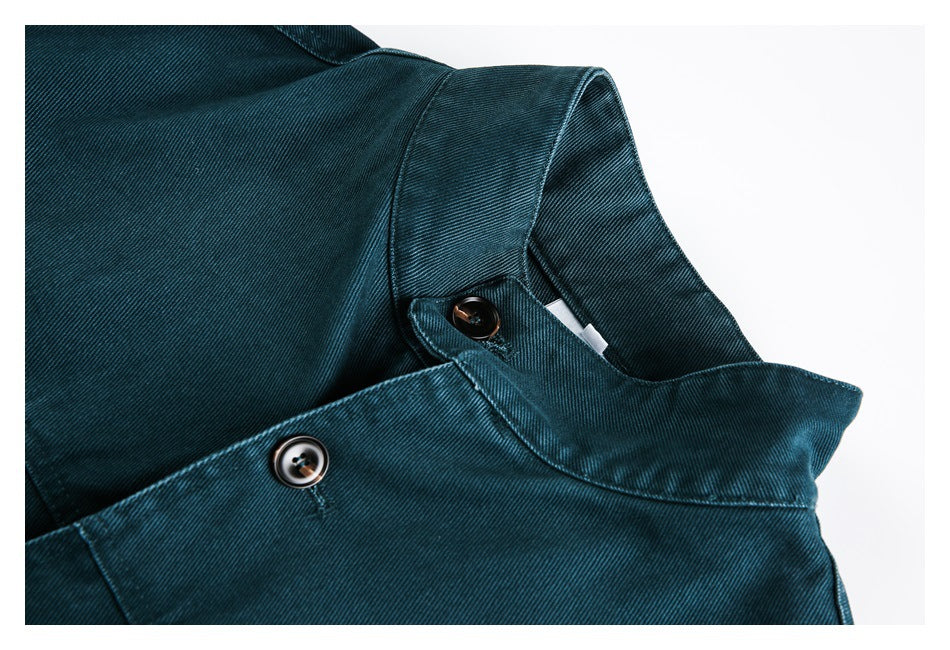 Close-up of the dark teal jacket's collar, fabric texture, and buttons.