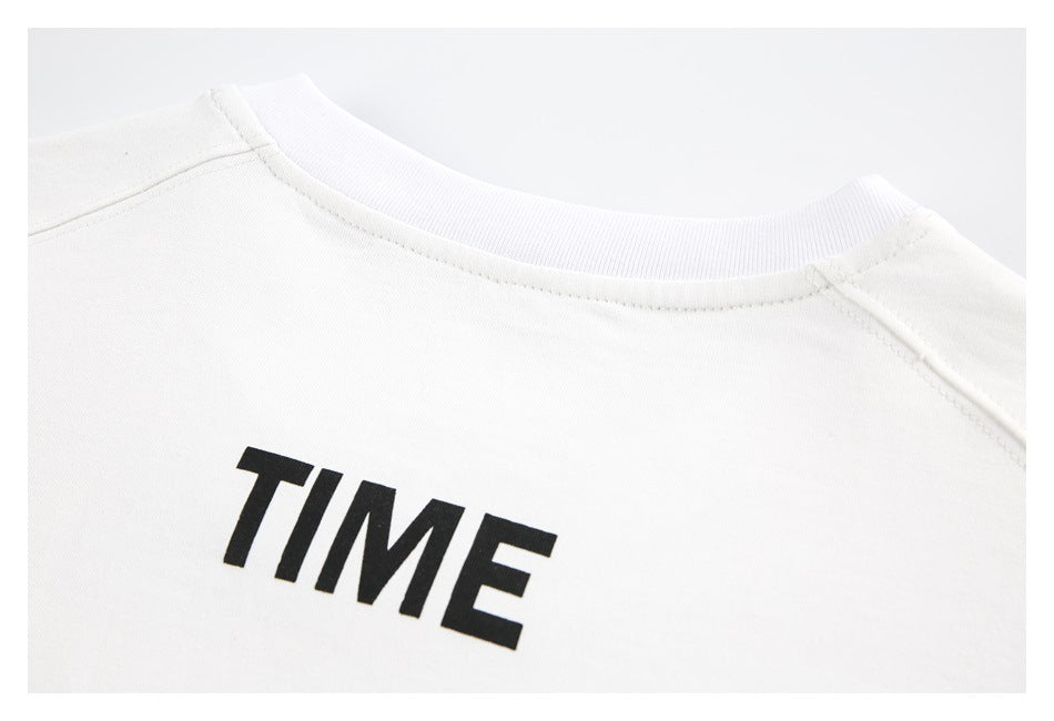 Close-up of a white crewneck garment with a ribbed collar and black TIME lettering.