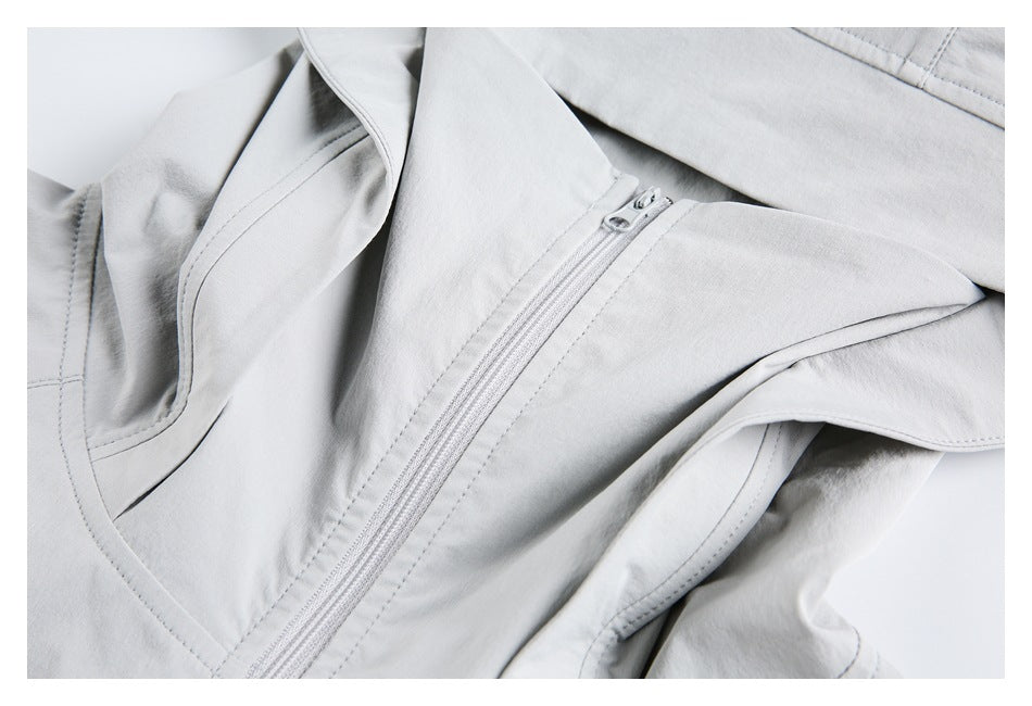 Close-up of the light gray jacket's front zipper and stitched panels.