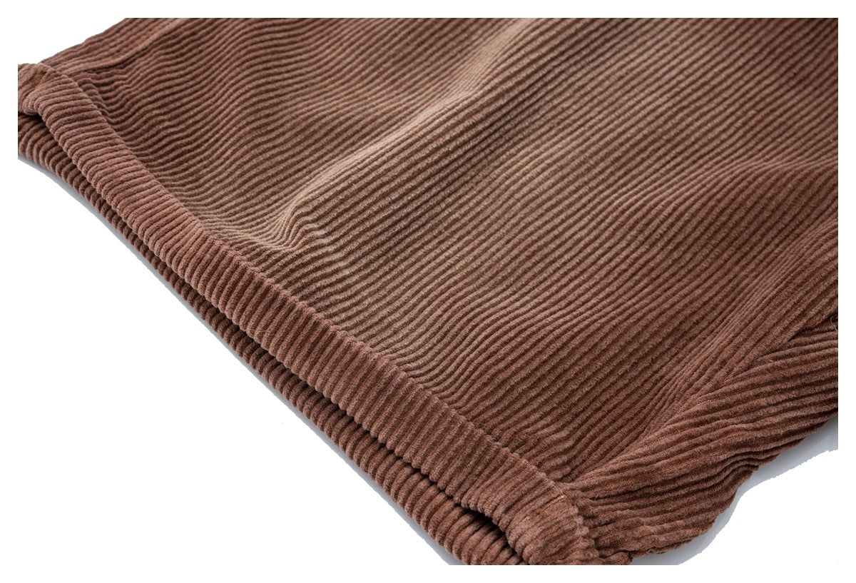 Close-up of a folded leg edge and stitching on brown corduroy trousers.