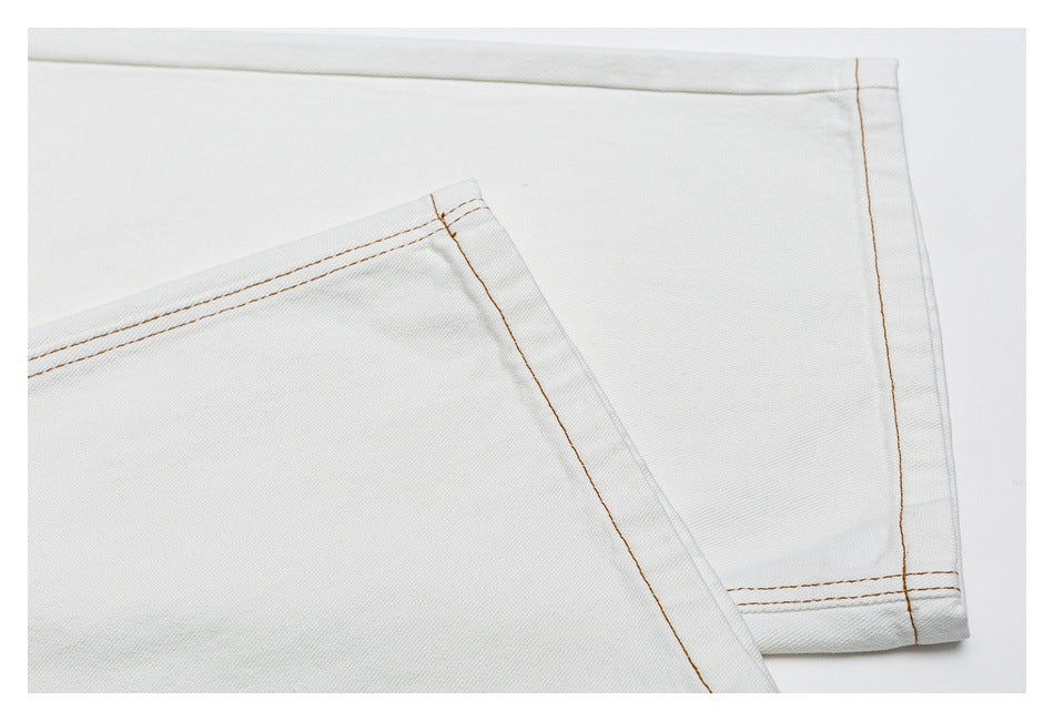 Close-up of the white jeans’ leg hems and double-stitched seams.