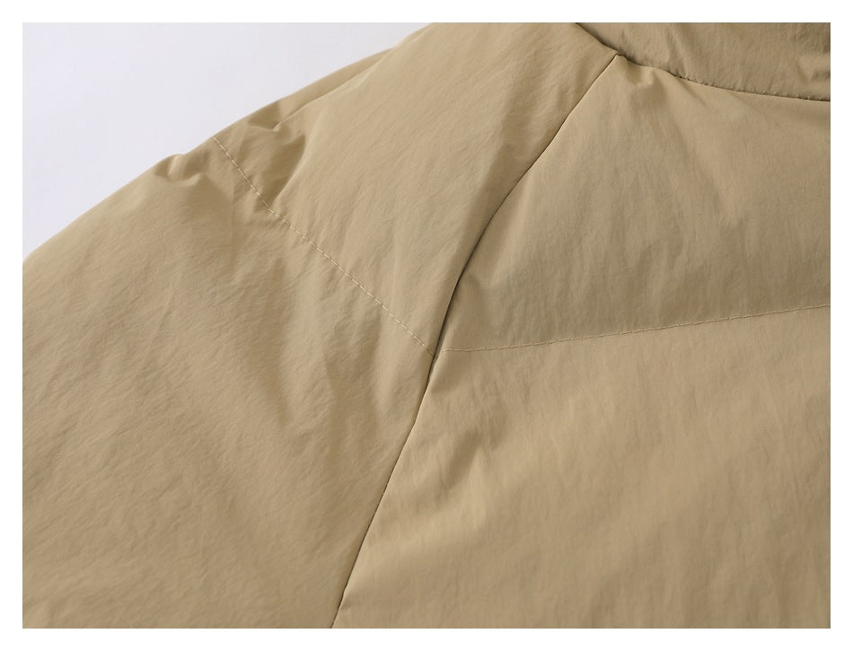 Close-up of the beige jacket's sleeve and shoulder seam stitching.