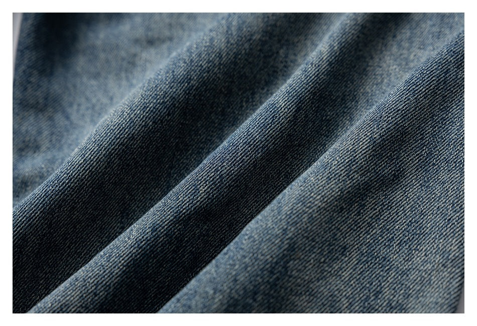 Macro view of the textured blue denim weave and faded finish.
