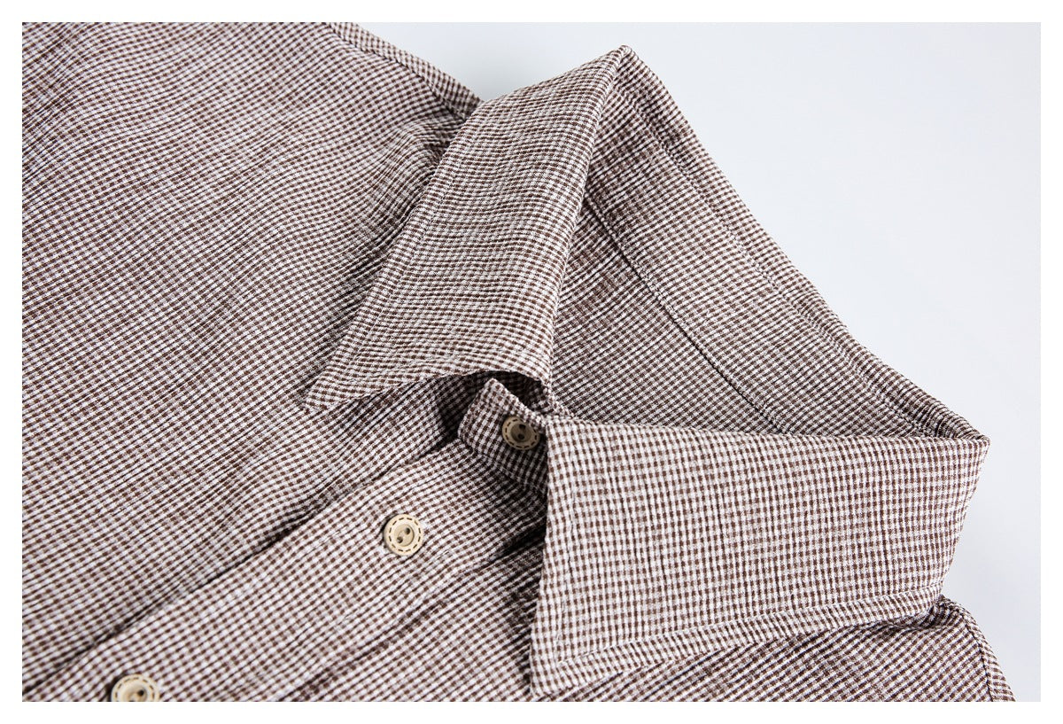 Close-up of a brown-and-white checked shirt collar and button placket.