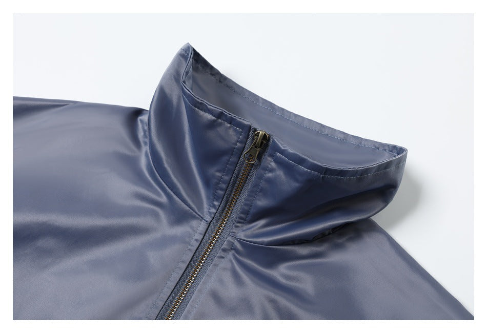 Close-up of the raised collar and brass-tone zipper on a slate blue jacket.