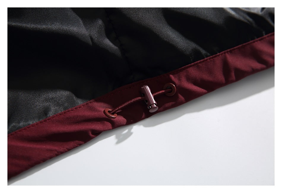 Close-up of the jacket's burgundy hem with an adjustable drawcord toggle against black lining.