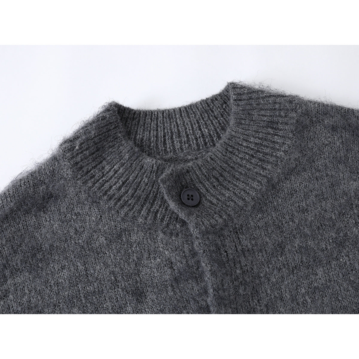 Close-up of a charcoal gray cardigan’s ribbed stand collar and single dark button.