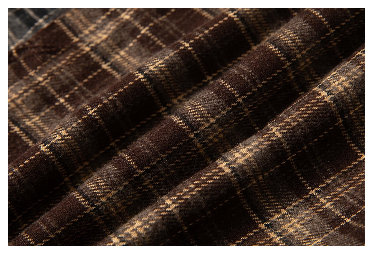 Macro view of brown plaid fabric showing its textured weave and intersecting tan lines.