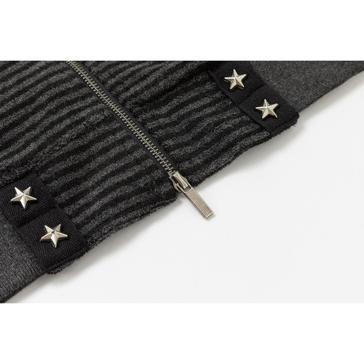 Close-up of the jacket's striped fabric, metal zipper, and silver star studs on black trim.