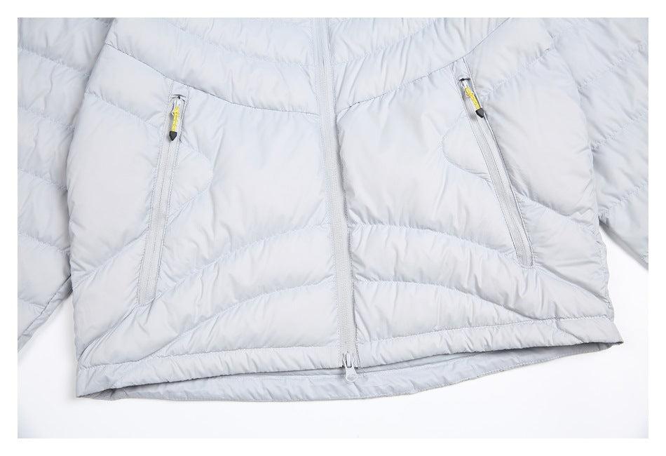 Close-up of a light gray quilted jacket showing two angled zip pockets and the front zipper.