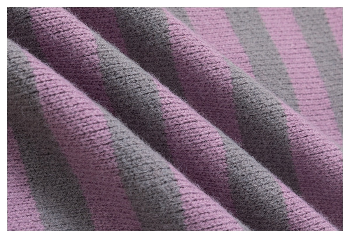 Close-up showing the textured pink and blue-gray striped knit fabric gathered into soft folds.