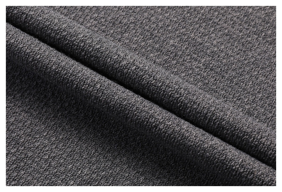 Close-up of textured gray knit fabric folded to show its raised stitches.