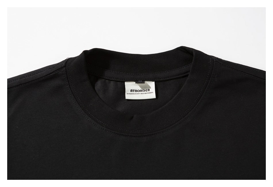 Close-up of a black crew-neck T-shirt showing the ribbed neckline, stitching, and a small inside neck label.