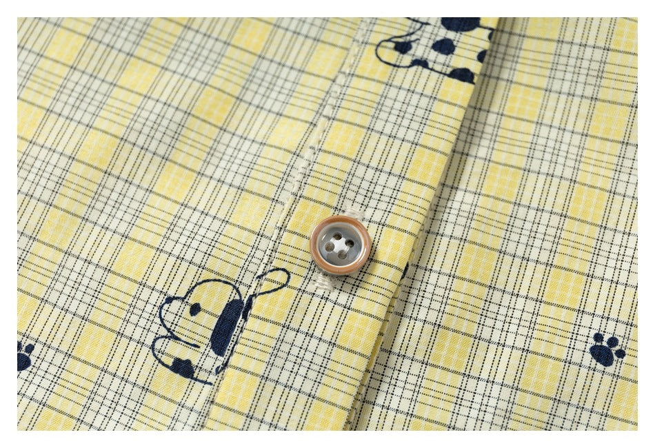 Close-up of a button, plaid fabric, and navy animal print on the shirt front.