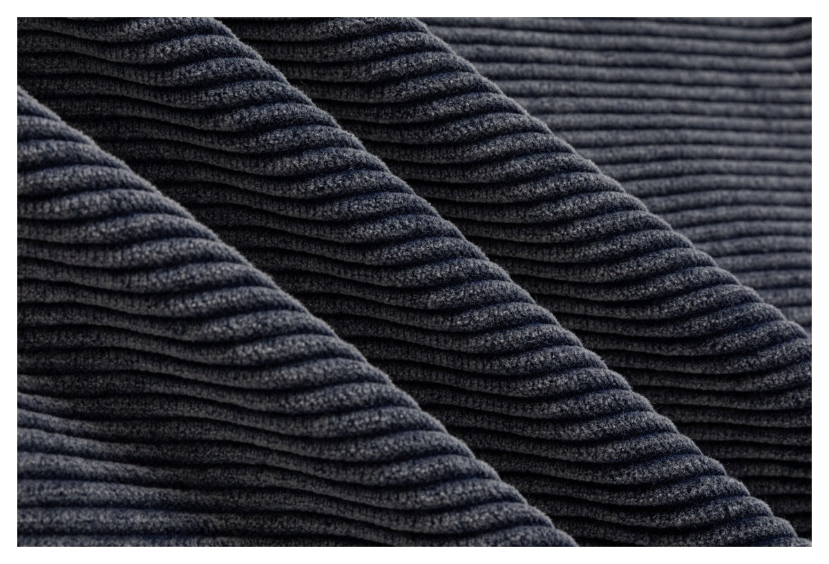 Macro view of the dark blue-gray garment's thick ribbed corduroy texture.