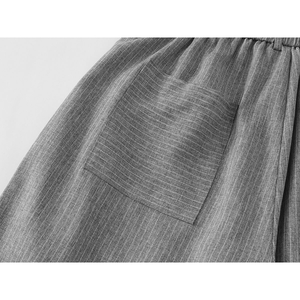 Close-up of a large patch pocket on gray pinstripe trousers.