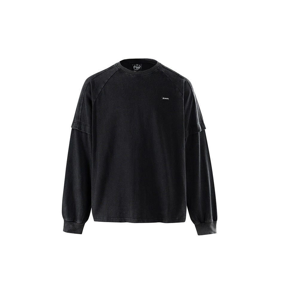 Washed black long-sleeve crew-neck top with raglan sleeves, layered sleeve detail and ribbed cuffs, front view