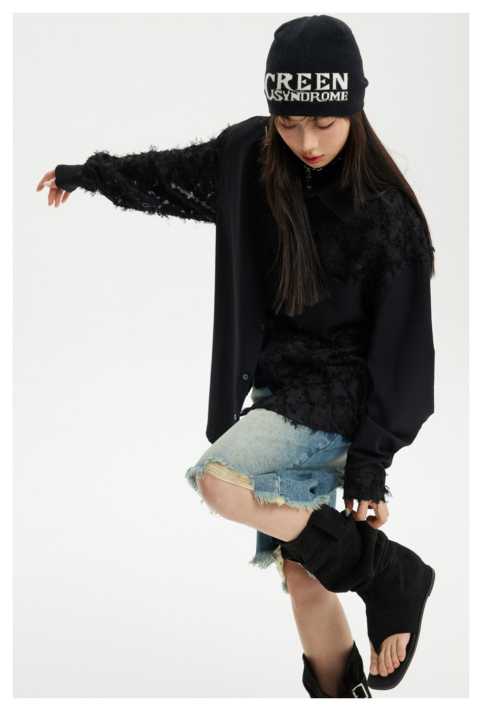 Model wearing a black textured-panel shirt with long sleeves, shown with distressed denim shorts and black boots.