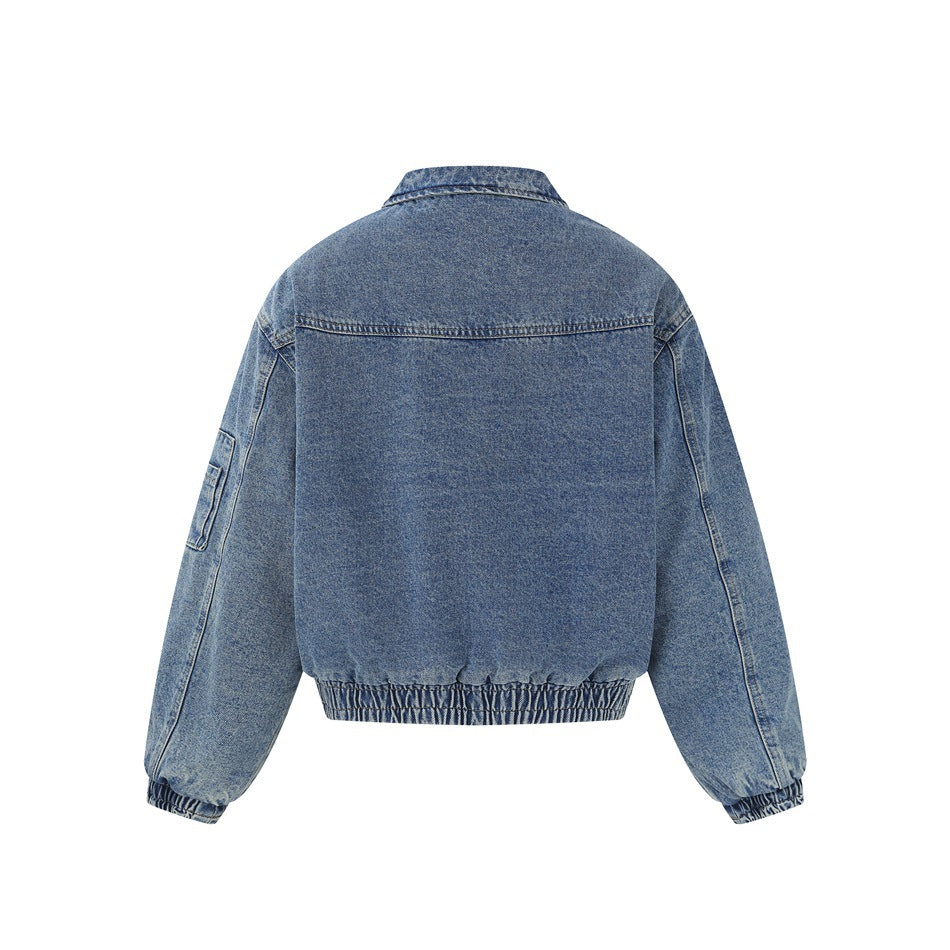 Back view of a blue denim jacket with a plain panel, long sleeves, and a gathered hem and cuffs.