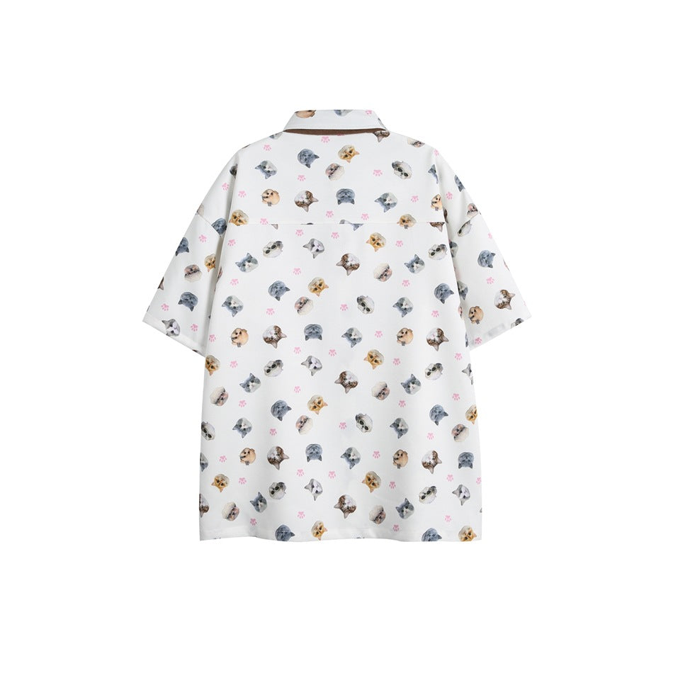 Back view of a white oversized short-sleeve shirt with scattered cat faces and pink paw prints.