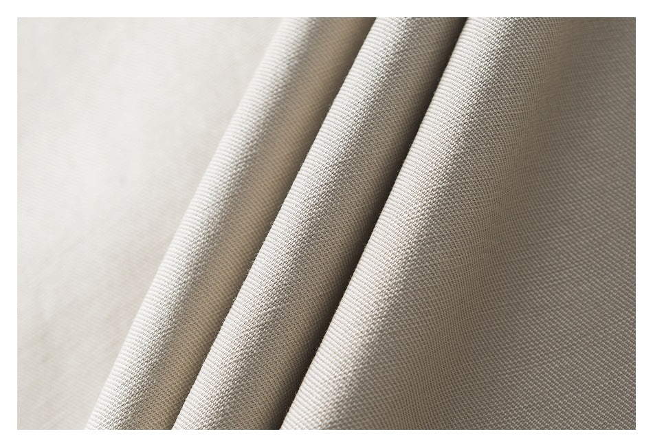 Macro view of beige fabric in soft folds, showing its woven surface texture.