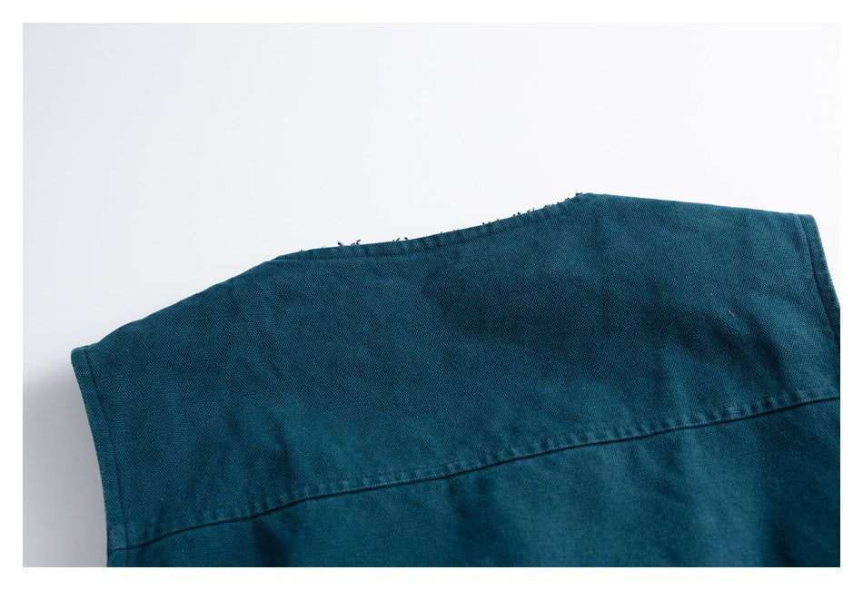 Close-up of teal garment fabric showing a curved upper edge and a curved stitched seam.