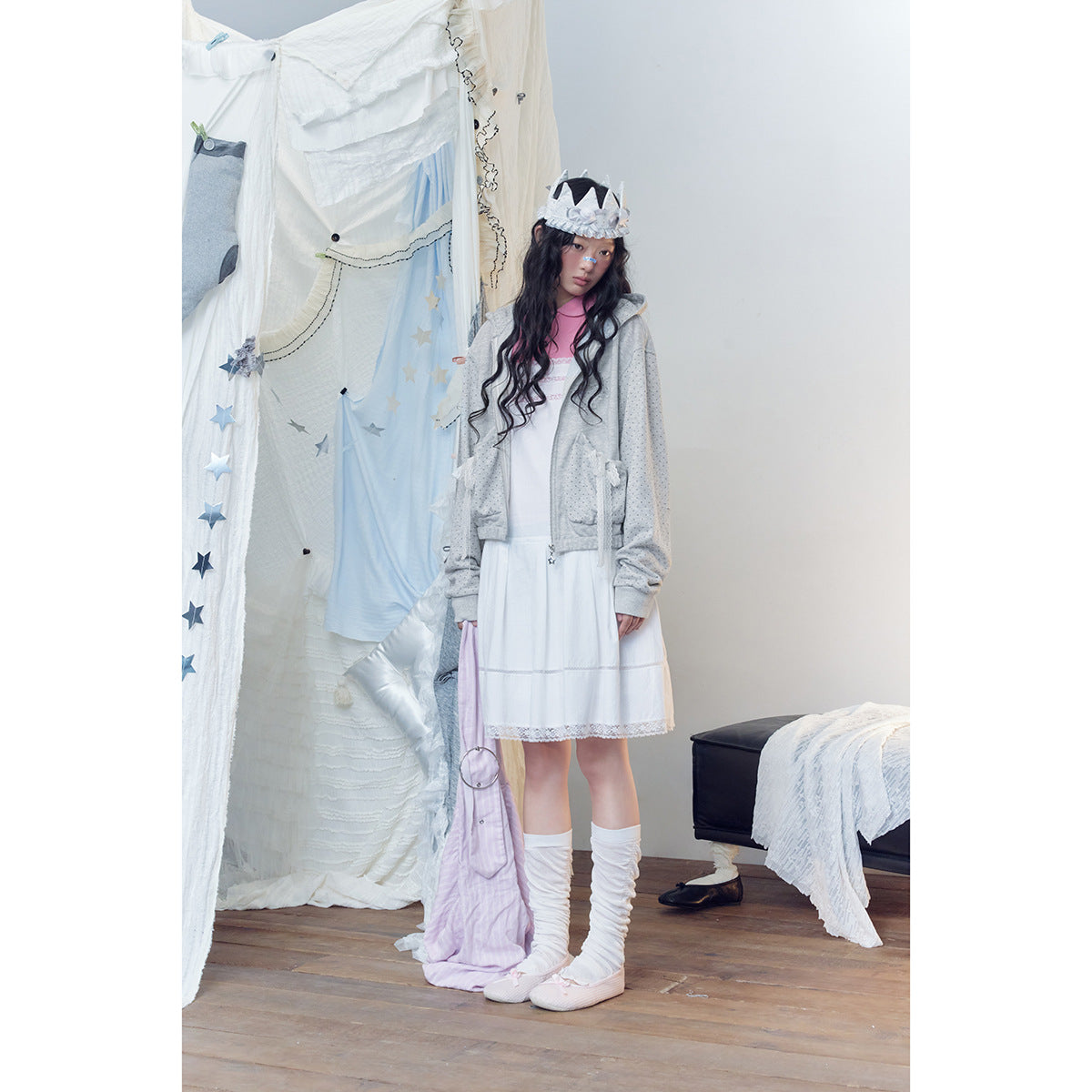 Full-length model wearing a light gray dotted hoodie over a white lace-trimmed dress with a pink collar.