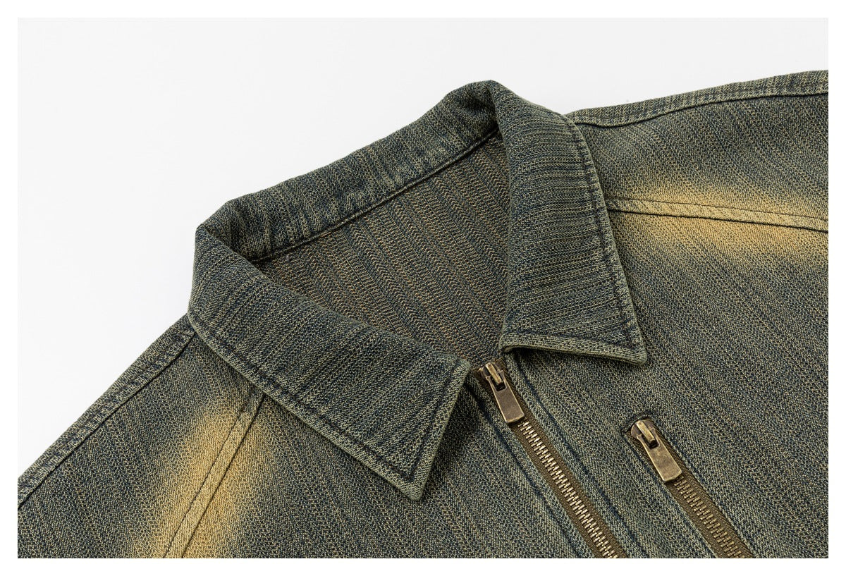 Close-up of the jacket’s pointed collar, distressed olive surface, and brass-tone front and chest pocket zippers.