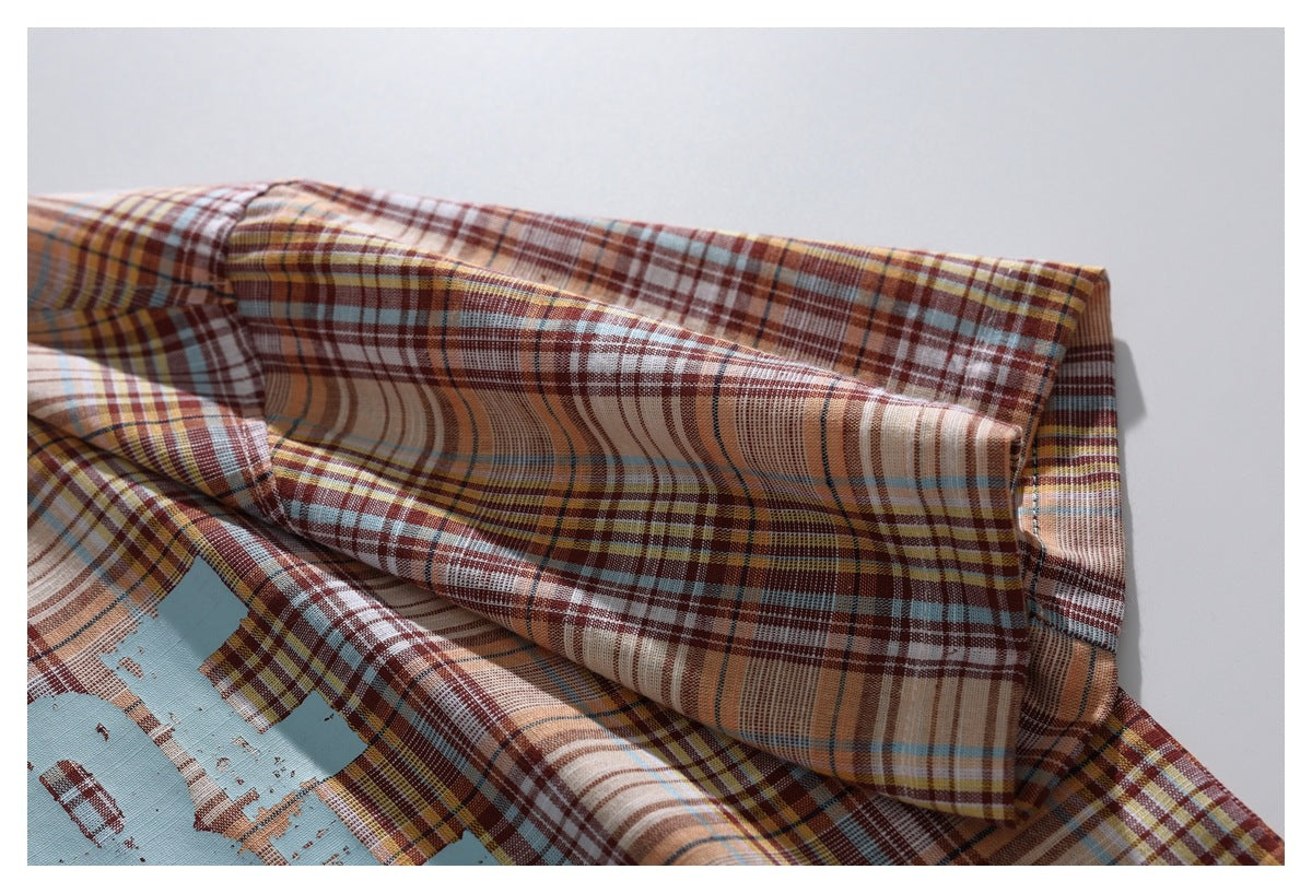 Close-up of the plaid shirt's collar and shoulder area, showing the checked pattern and stitching.