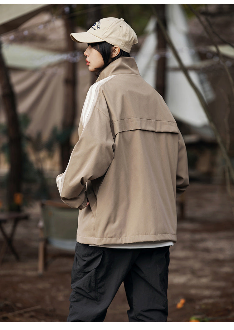 Back and side view of a model wearing the khaki jacket with a back yoke seam and cream sleeve stripe, outdoors