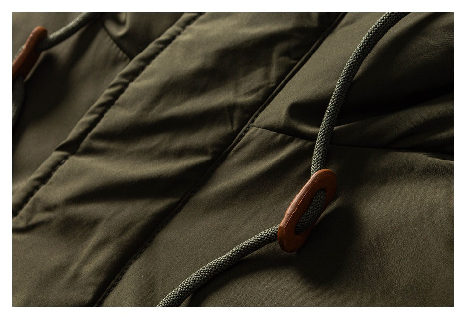 Close-up of an olive jacket drawcord threaded through a brown toggle.