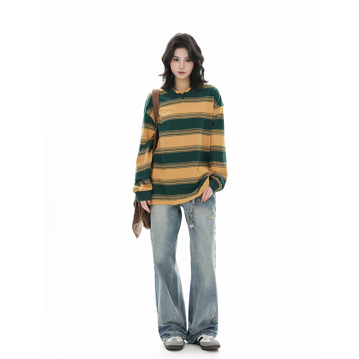 Full-length model wearing an oversized green and mustard striped long-sleeve shirt with loose light-wash jeans.