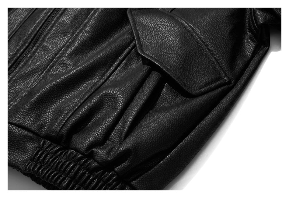 Close-up of a black pebbled jacket showing a flap pocket and gathered elastic hem.